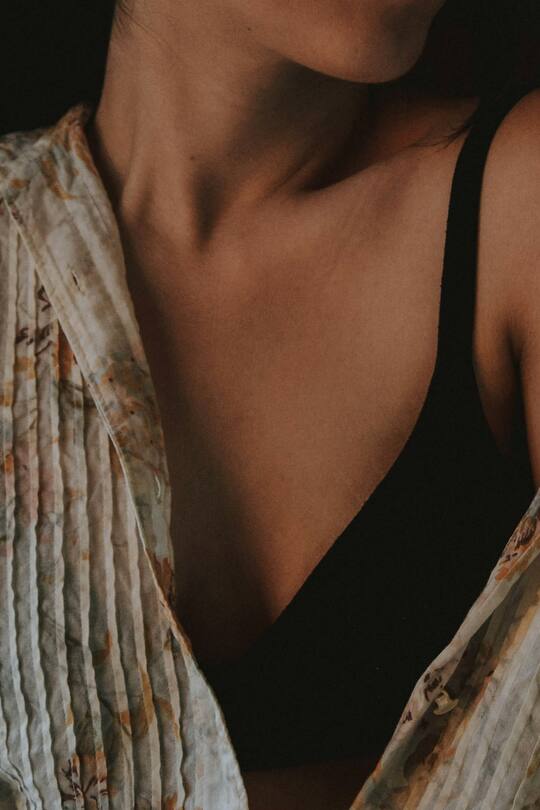 Frau in BH mit Bluse darüber.