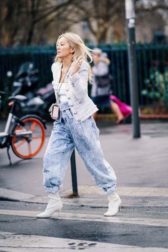 PARIS, FRANCE - MARCH 01: Tina Leung wears a white tweed jacket with buttons, blue jeans, white shoes with heels, a white top, outside Balmain, during Paris Fashion Week Womenswear Fall/Winter 2019/2020, on March 01, 2019 in Paris, France. (Photo by Edward Berthelot/Getty Images)