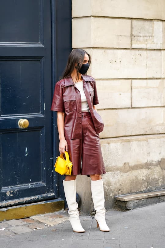 PARIS, FRANCE - OCTOBER 04: Alice Barbier wears a t-shirt, a burgundy leather jacket with short sleeves, a yellow leather bag, shorts, white knee-high boots, outside Gabriela Hearst, during Paris Fashion Week - Womenswear Spring Summer 2021, on October 04, 2020 in Paris, France. (Photo by Edward Berthelot/Getty Images)
