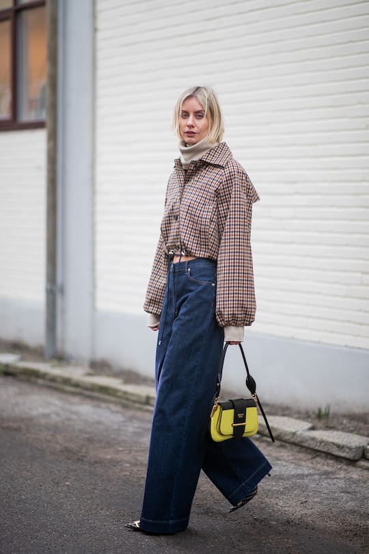 COPENHAGEN, DENMARK - JANUARY 31: Lisa Hahnbueck is seen wearing cropped plaid jacket, wide leg denim jeans, yellow black Prada bag, turtleneck outside Baum und Pferdgarten during the Copenhagen Fashion Week Autumn/Winter 2019 - Day 3 on January 31, 2019 in Copenhagen, Denmark. (Photo by Christian Vierig/Getty Images)
