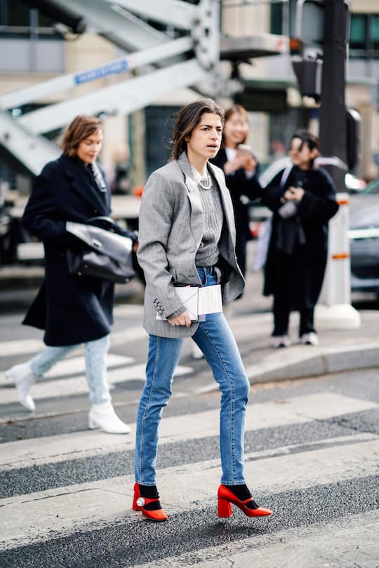 PARIS, FRANCE - MARCH 05: A guest wears a pearl necklace, a grey sweater, a grey Prince of Wales check jacket, jeans, red Miu Miu shoes, outside Miu Miu, during Paris Fashion Week Womenswear Fall/Winter 2019/2020, on March 05, 2019 in Paris, France. (Photo by Edward Berthelot/Getty Images)