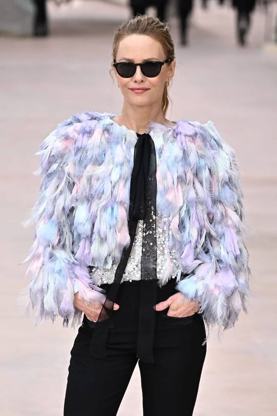 Vanessa PARADIS, CHANEL Ambassador, wore a blue organza blouson, look 71, with silver glitter guipure top, look 22, from the Spring-Summer 2025 Ready-to-Wear collection with CHANEL black trousers. CHANEL bag and shoes. Coco Crush Toi & Moi Ring in 18K beige gold, diamonds. CHANEL Fine Jewelry. Extrait de Camélia Earrings in 18K pink gold, diamonds. CHANEL Fine Jewelry. CHANEL Makeup.