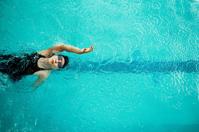 View from directly above a paraplegic woman training in a pool for competitive swimming.