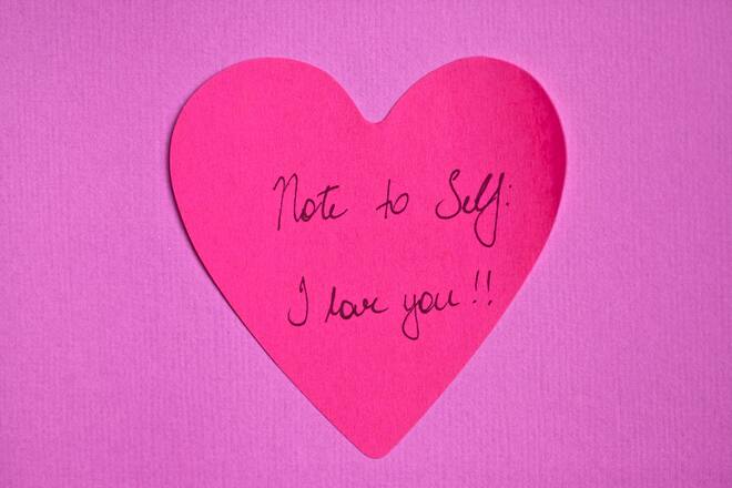 A pink heart notepaper on a purple background with a reminder of self-love.