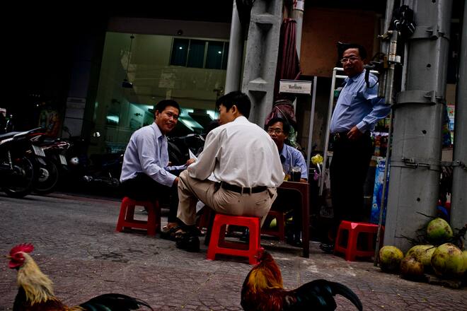 Office workers eat breakfast on the streets in downtown Ho Chi Minh City, Vietnam, on Tuesday, Dec. 27, 2011. Vietnam's gross domestic product growth is estimated at 5.9 percent this year, according to a statement on the government's website last week. Photographer: Justin Mott/Bloomberg via Getty Images