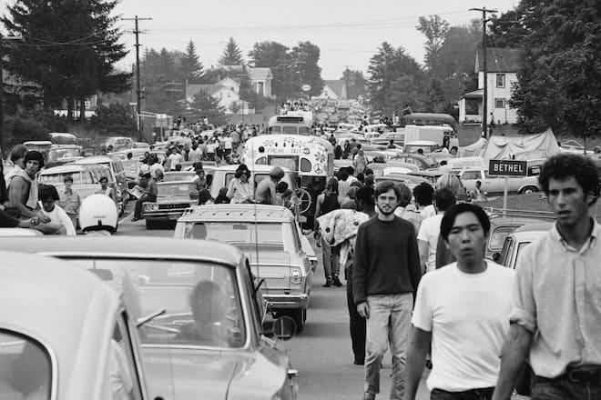 Members of the American youth subculture generally termed 'hippies' walk along roads choked with traffic on the way to the large rock conert called Woodstock, Bethel, New York, August, 1969. Sometimes likeminded motorists give them rides in or on their vehicles. (Photo by Hulton Archive/Getty Images)