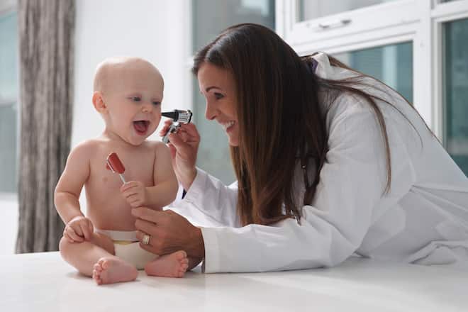 Fröhliches Baby mit Kinderärztin