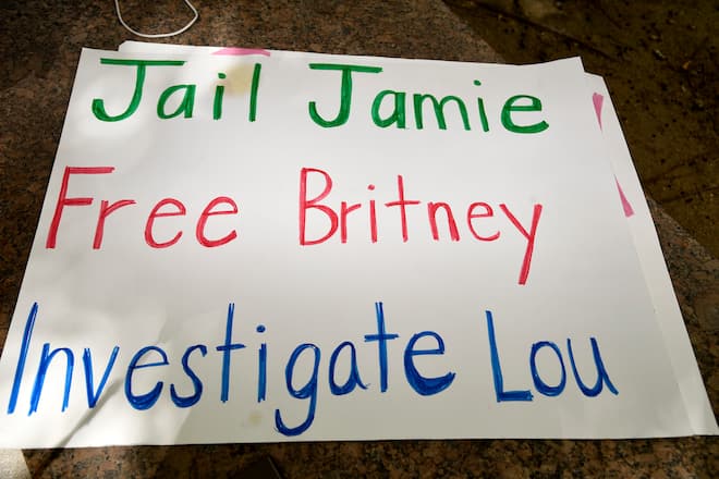 LOS ANGELES, CALIFORNIA - JULY 22: A sign that reads "Jail Jamie, Free Britney, Investigate Lou" sits on the ground as supporters of Britney Spears gather outside a courthouse in downtown for a #FreeBritney protest as a hearing regarding Spears' conservatorship is in session on July 22, 2020 in Los Angeles, California. Spears was placed in a conservatorship managed by her father, James Spears, following her involuntary hospitalization for mental care in 2008. (Photo by Frazer Harrison/Getty Images)