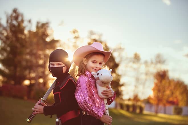 girl and boy dressed as ninja and cowgirl on Halloween.
