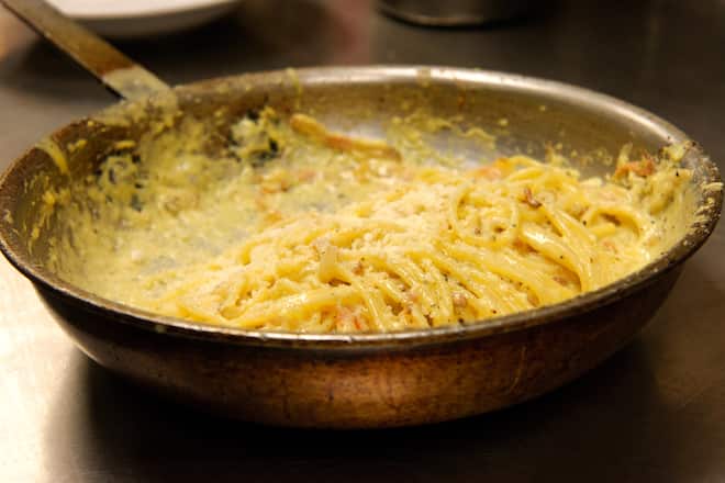 Cooking spaghetti carbonara in a copper pan