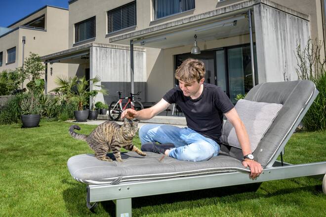 Marc Hirschi, U23-Weltmeister im Radfahren, steht vor seiner ersten Tour de Suisse, ausruhen mit Katze Mira im Garten. Aufgenommen in Ittigen. Bild © Remo Naegeli
